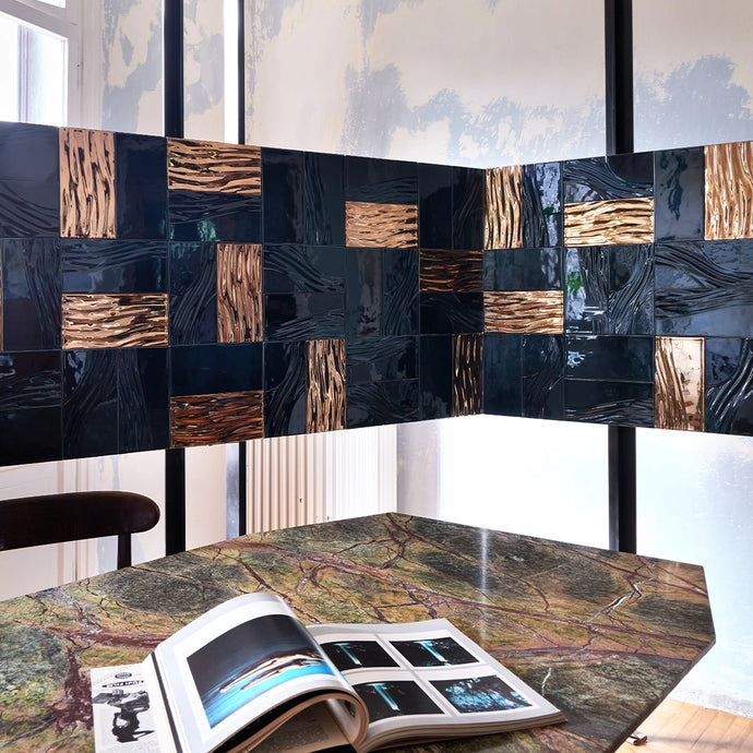 Botteganove Barene collection with dark blue and rose gold tiles above a marble table