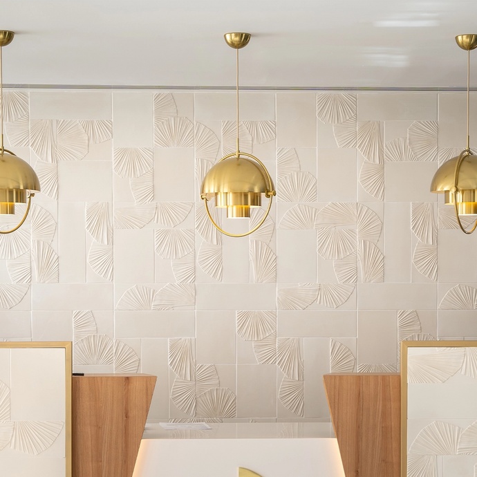 Space with golden lamps and off-white Botteganove Flora tiles at the wall