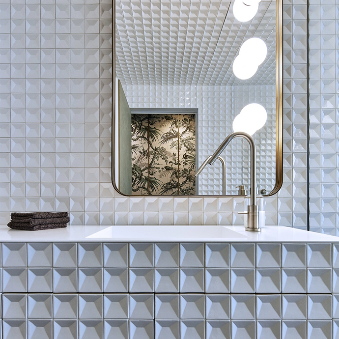 Sanitary space with golden mirror, white sink and white Botteganove Perspectives tiles