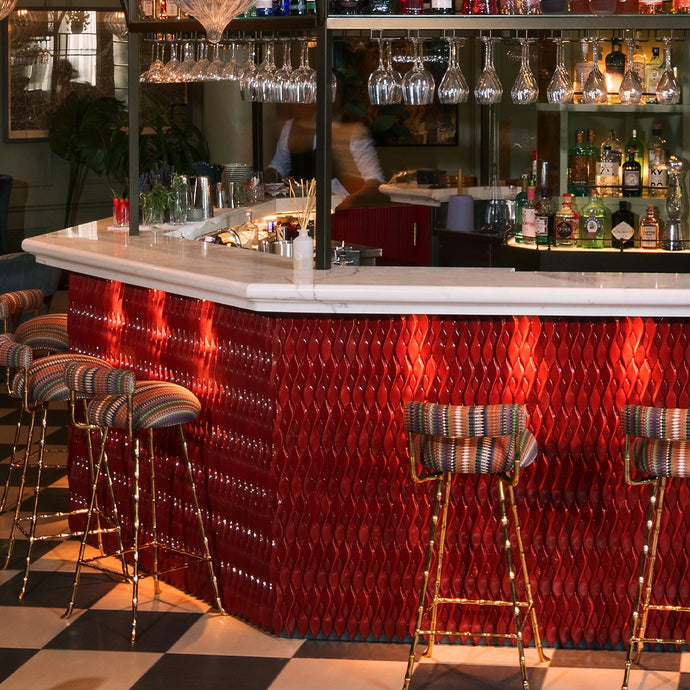 Bar with nice colorful chairs and a bar with red Botteganove Salomè tiles